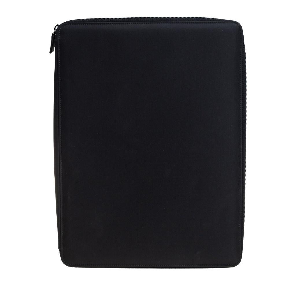 This Prada document holder made from black nylon is perfect for carrying your work documents in style. It has a leather-lined interior equipped with slots for cards, pens, papers and is secured with a zipper.


