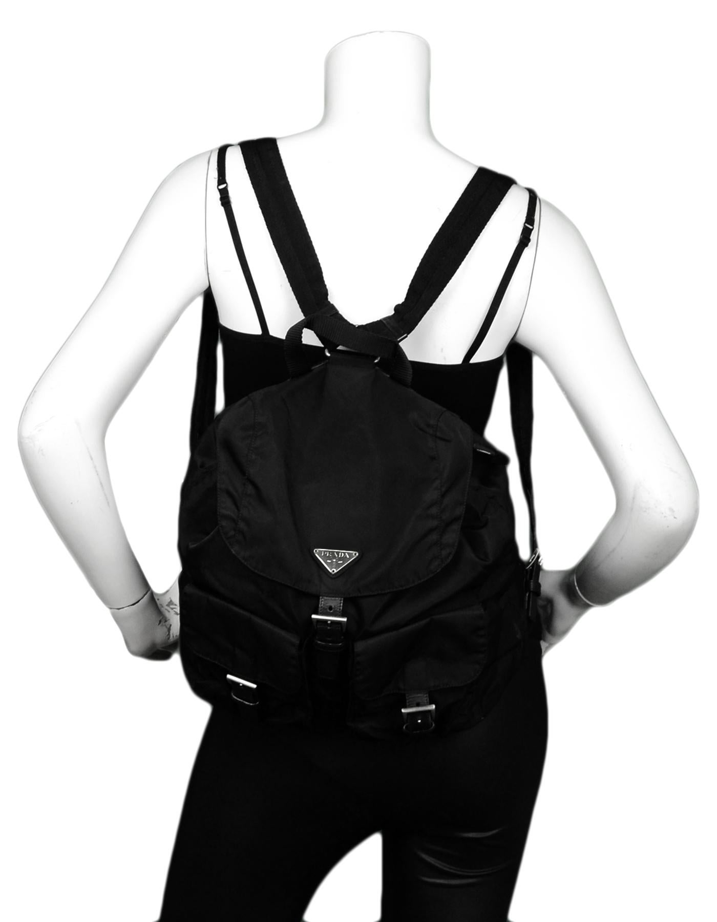 Prada Black Nylon Double Buckle Pocket Backpack Bag

Made In: Italy
Color: Black 
Hardware: Silvertone
Materials: Nylon with leather trim and canvas straps
Lining: Black logo textile 
Closure/Opening: Flap top with magnetic and buckle