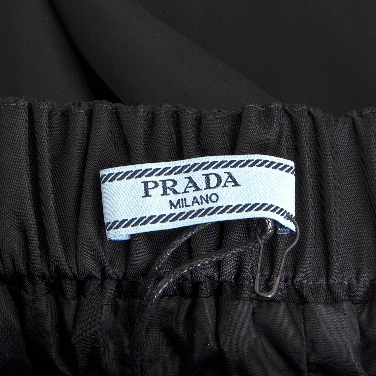 100% authentic Prada knee-length flared skirt in black nylon (100%) with elastic waistband and bow detail at front. The design comes with side pockets. Lined in black nylon (100%). Has been worn and is in excellent condition. 

Measurements
Tag