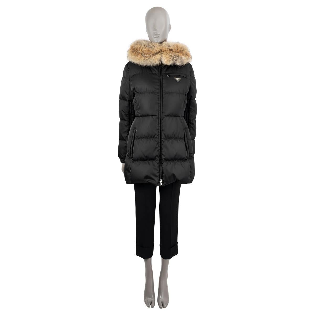 100% authentic Prada quilted down parka in black polyamide (100%). Features a natural coyote fur trim along the hood, side slit zip-pockets, zipped chest-pocket, two internal zip-pockets and zipper on the inner sleeve. Opens with a two-way zipper.