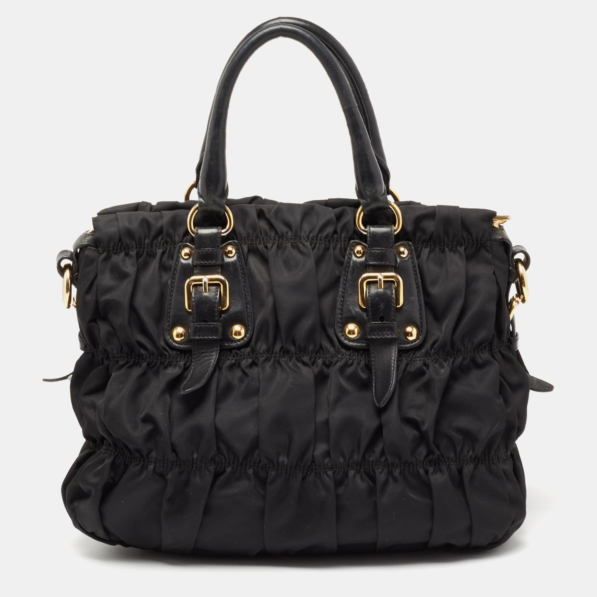 Carry your daily essentials in style in this Prada Gaufre ruched shopping bag. It comes crafted in fine materials. The exterior features double top handles and gold-tone detailing. The top zipper opens to a roomy interior and features a zipper