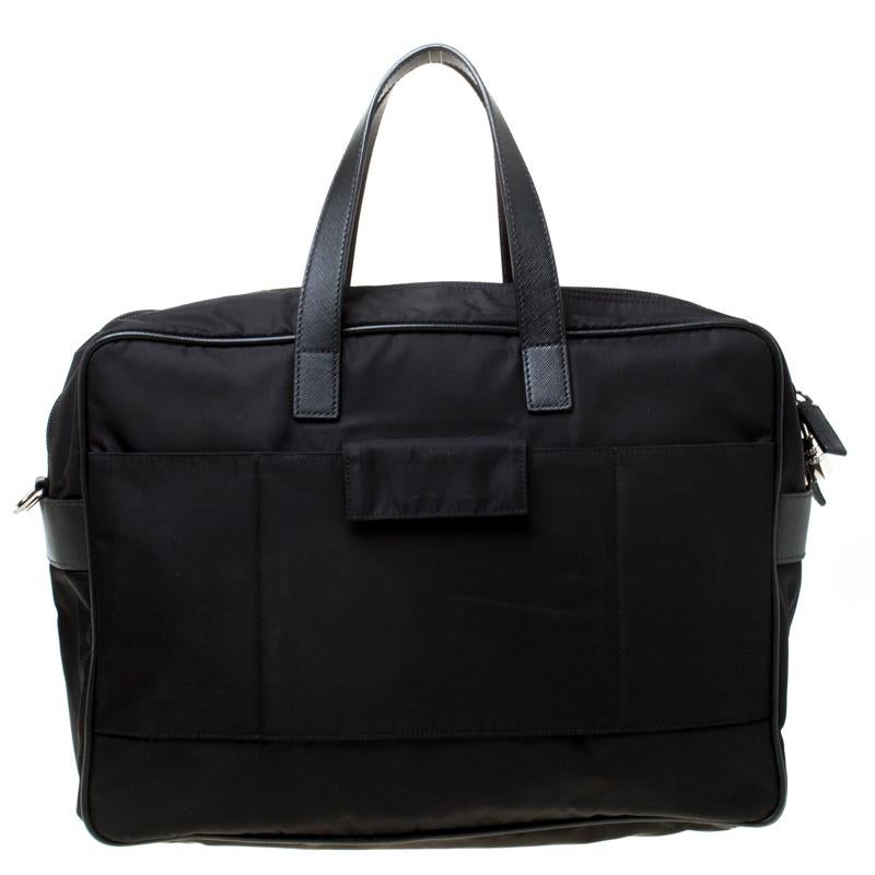 Diese Laptoptasche von Prada ist der perfekte Begleiter für jeden Anlass. Sie ist aus Nylon gefertigt und trägt das Markenlogo auf der Vorderseite. Sie wird von zwei Griffen gehalten und verfügt über eine Reißverschlusstasche auf der Vorderseite.