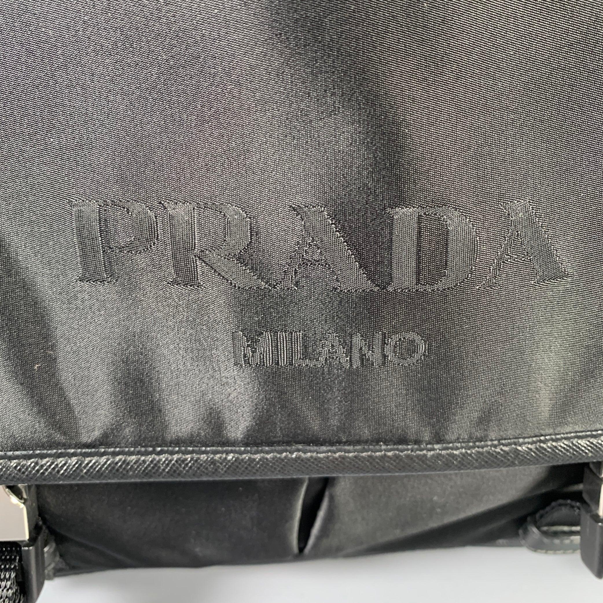 PRADA bag comes in a black nylon featuring a messenger style, silver tone hardware, adjustable cross body strap, inner pockets, and a silver tone buckle. Includes dust bag. Made in Italy. Very Good Pre-Owned Condition. Signs of wear. 

Measurements: