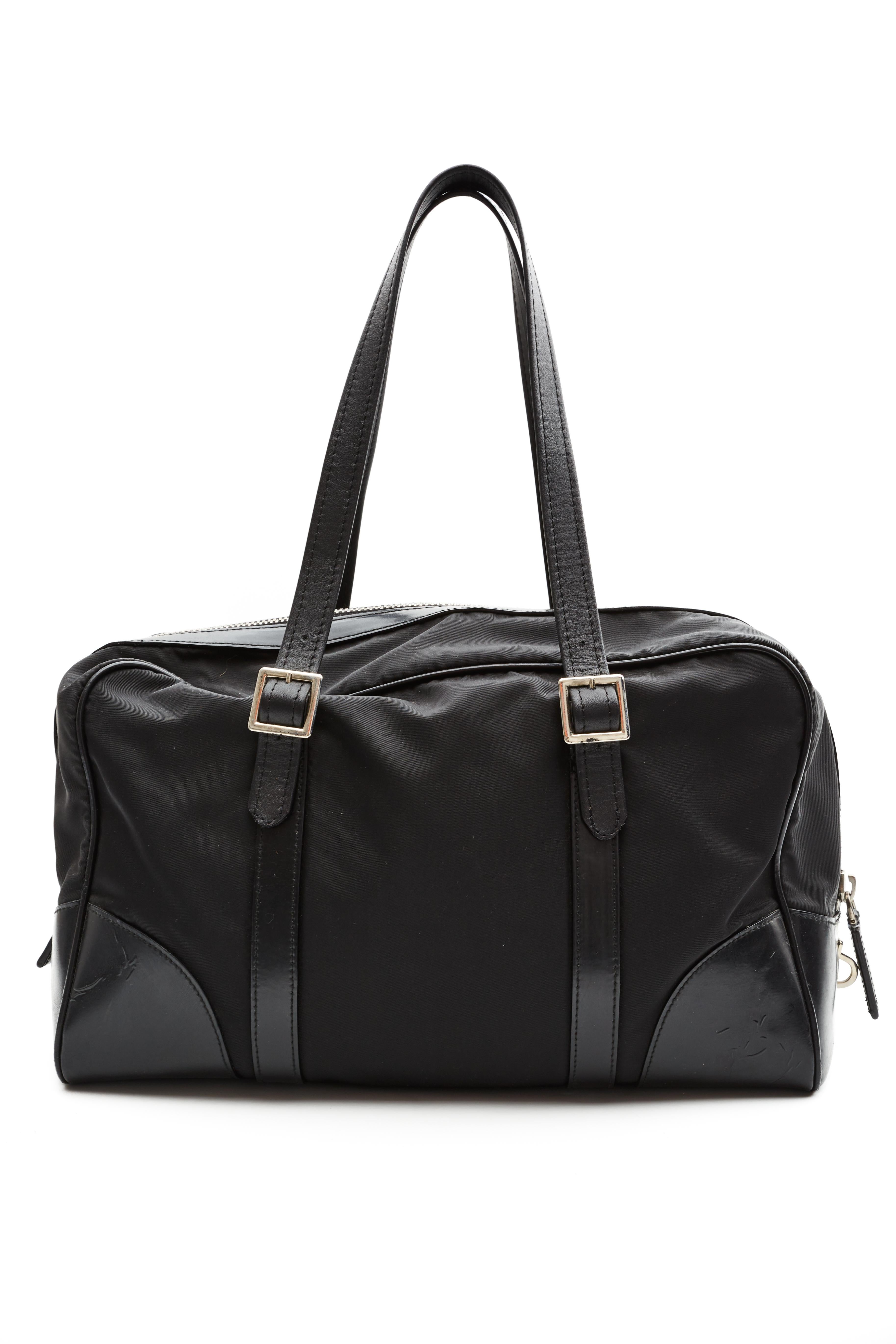 Ce sac Prada est réalisé avec des finitions en nylon et en cuir noir. Le sac est doté d'anses plates en cuir, d'une fermeture zippée sur le dessus et d'une doublure intérieure ornée du logo et du motif jacquard emblématiques de Prada.

COULEUR :