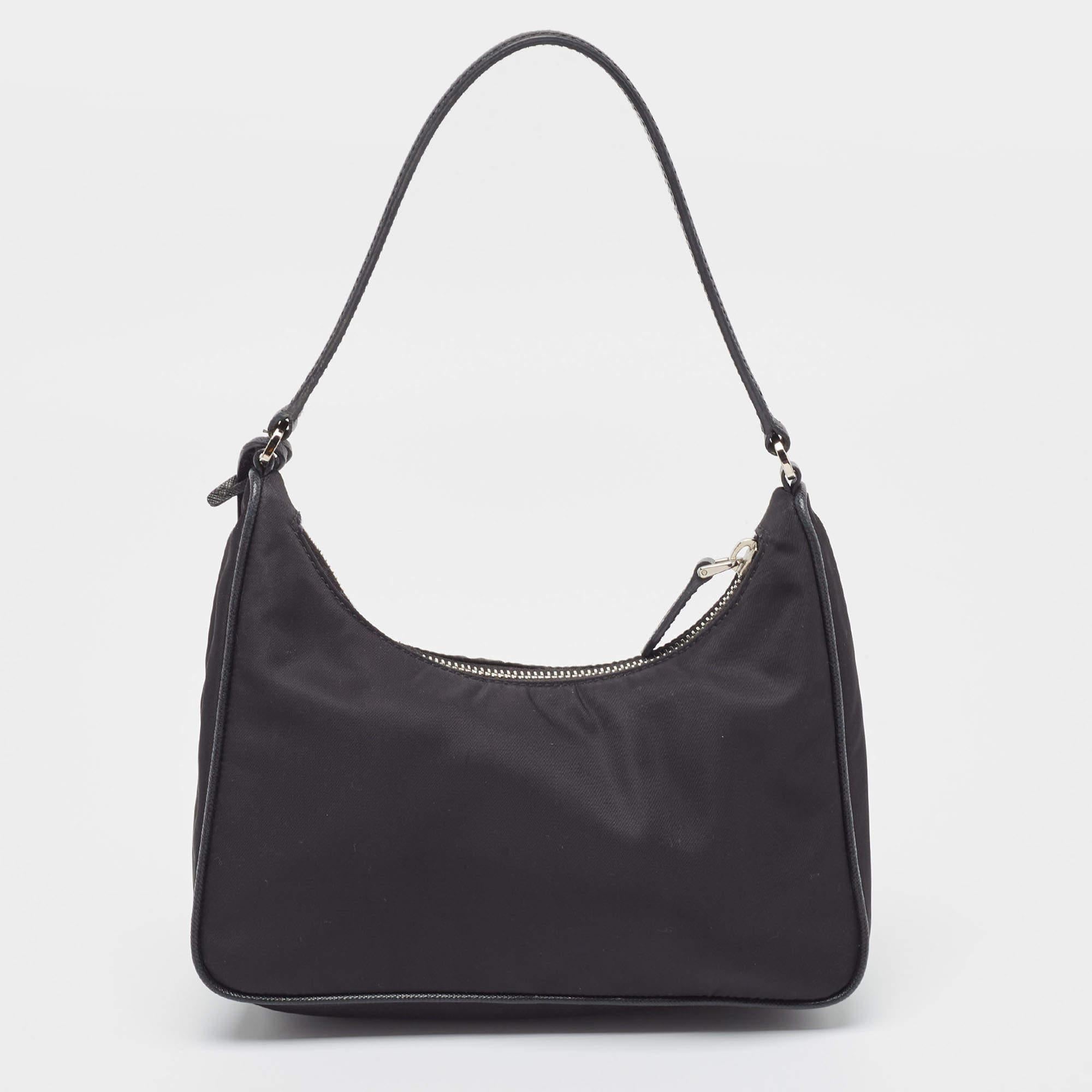 The petite silhouette and classic elements made the Prada Re-Edition 2005 bag an instant hit among fashionistas. Inspired by the classic mini hobo bag, this black creation comes made from nylon and features a pouch attached to the single handle at