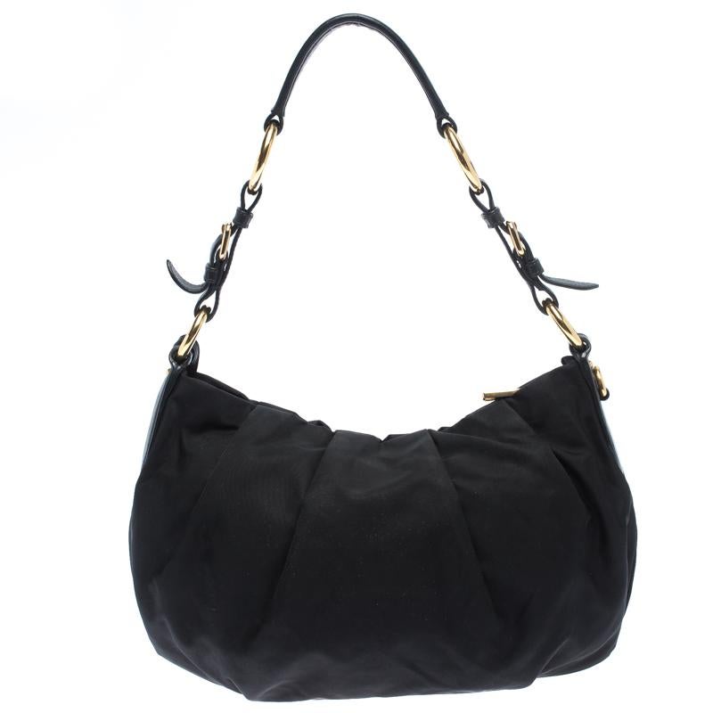 Make stunning addition to your accessory collection with this rich and fabulous Prada bag. Crafted from nylon with interiors lined in fabric, this bag is skillfully crafted. The bag features a single handle and gold-tone hardware.

Includes: The