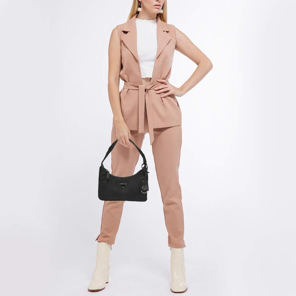 The Prada Nylon Re Edition 2000 Baguette Bag offers a sleek contemporary design with a nod to the early 2000s. Crafted from durable nylon and featuring the iconic enamel triangle logo this timeless piece is perfect for both casual outings and more