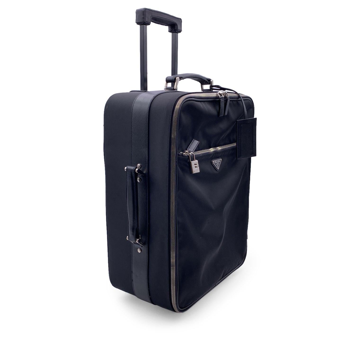 Gorgeous Prada Rolling Luggage Trolley travel bag. Black nylon, saffiano leather trim and fabric lining. Prada triangle logo on the front. Silver metal hardware. Double zipper closure. 1 front zip pocket and 1 rear zip pocket . Top handle and side