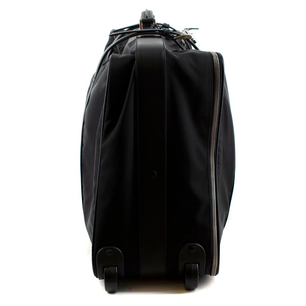 Prada Black Nylon & Saffiano Leather Semi-Rigid Suitcase

- Nylon with Saffiano leather handle and trim
- Polished steel hardware and dark metal zipper
- Logo lining
- Tag logo inside, triangle enameled logo outside on the front
- One compartment