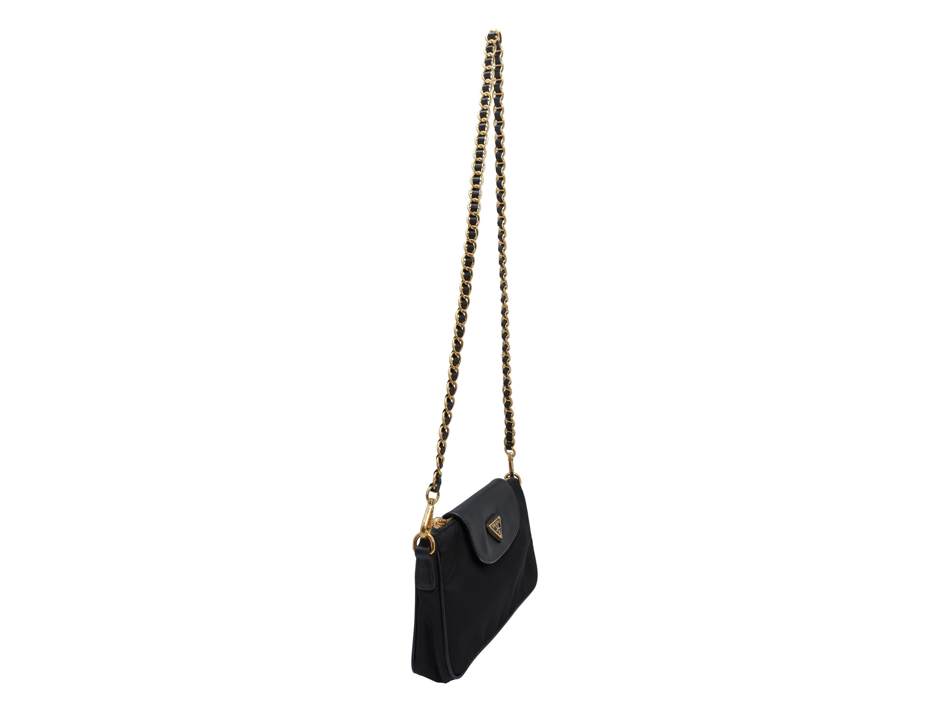 Product details: Black nylon and Saffiano leather mini bag by Prada. Gold-tone hardware. Chain strap. Zip closure at top. 8.75