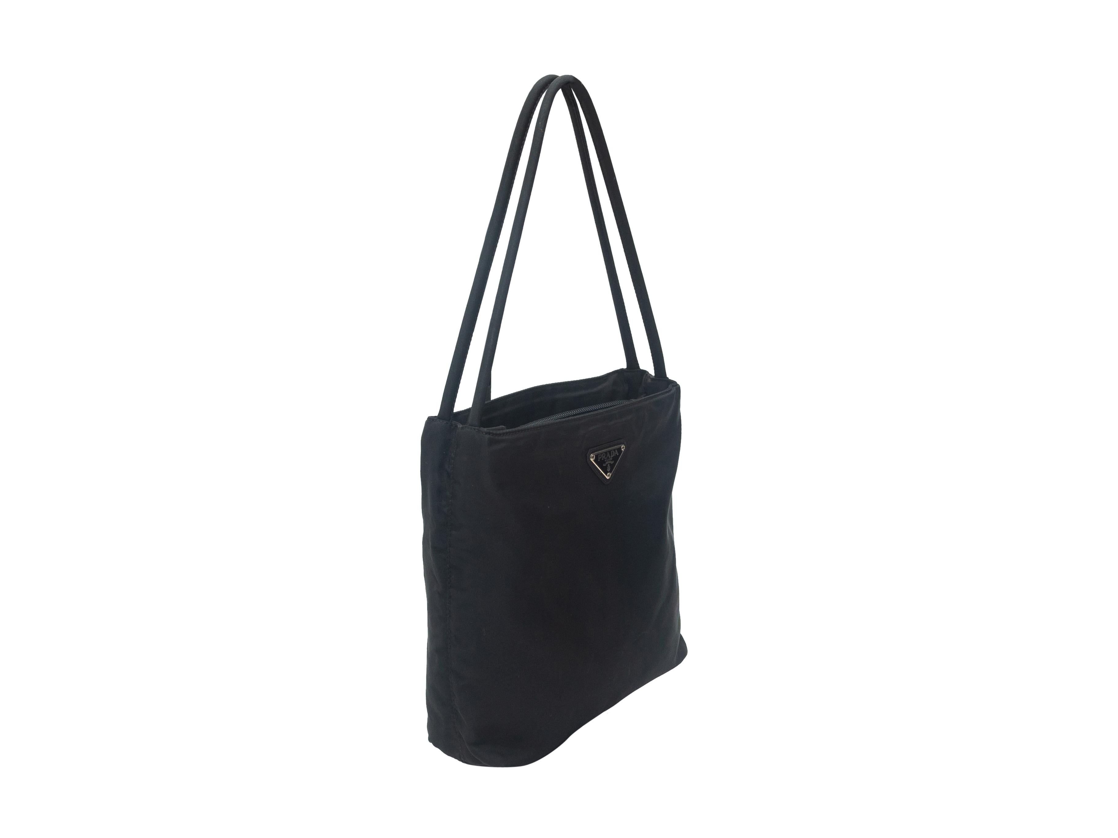 Product details: Black nylon small shoulder bag by Prada. Interior zip pocket. Dual shoulder straps. 9