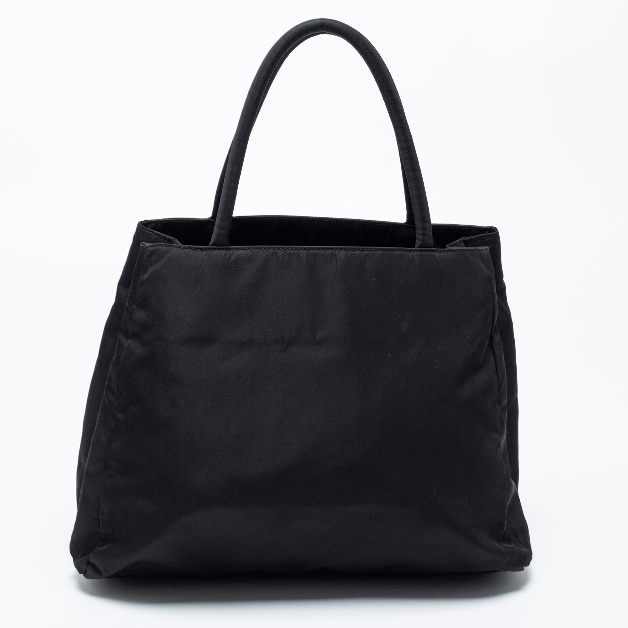 This Prada tote strikes the right balance between fashion and function. Crafted from nylon, it flaunts a brand signature on the front, dual handles at the top, and a fabric-lined interior.

