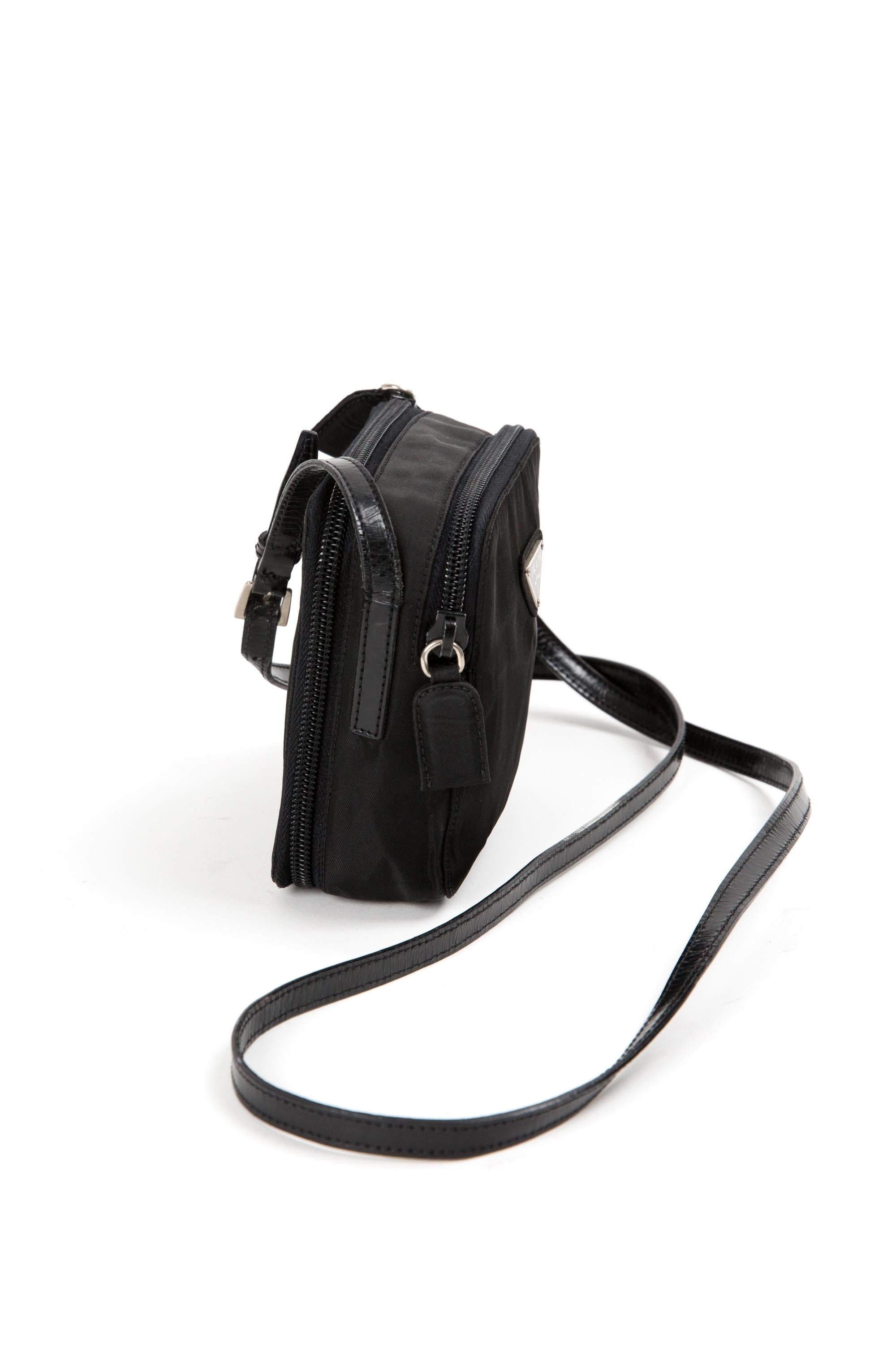 Prada black nylon Tessuto mini shoulder bag featuring the enameled metal triangle logo on the front, an adjustable shoulder/crossbody strap (Shoulder strap length: 47.6 in (121cm), a compartment with top zipper closure and interior logo lining, a