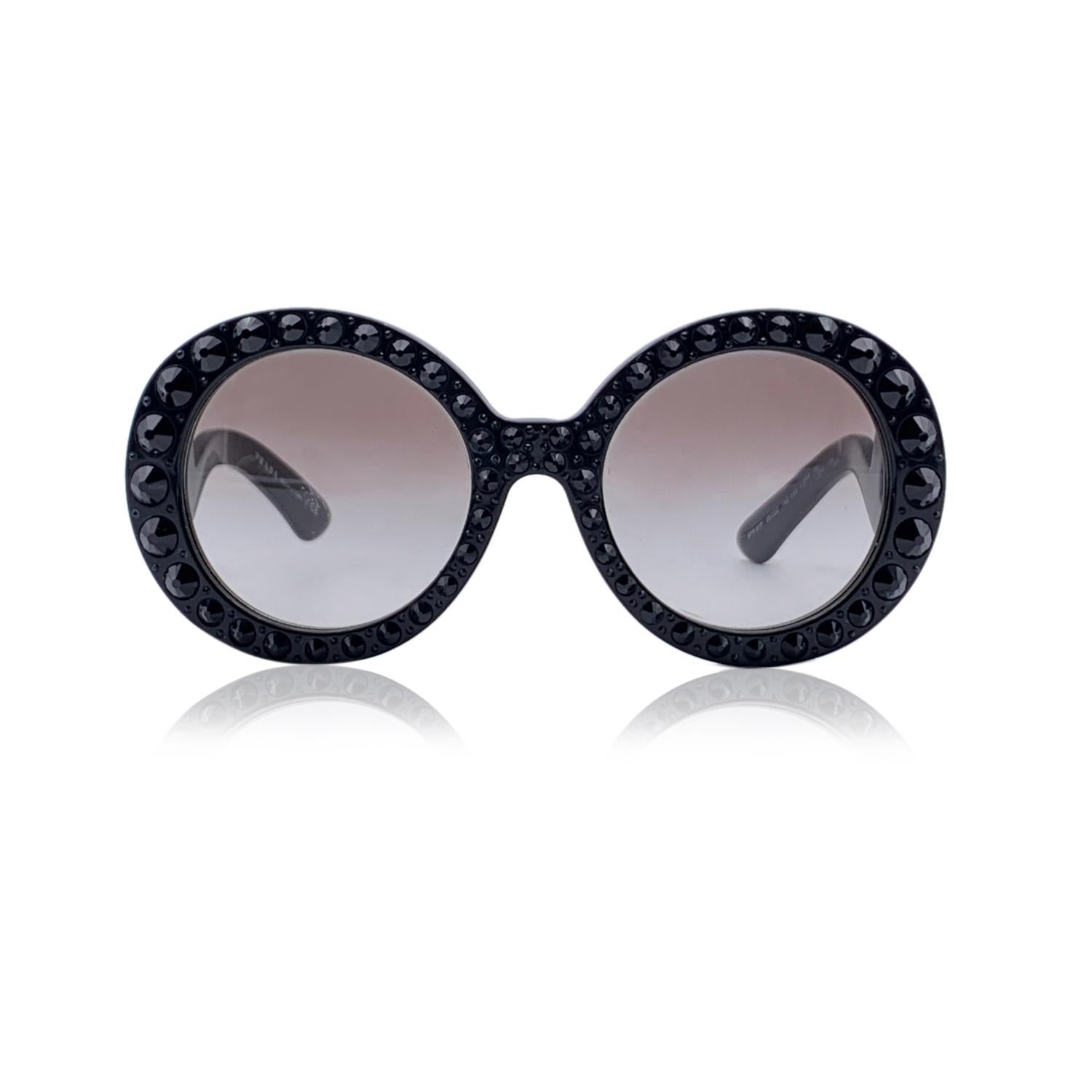 Stunning sunglasses by Prada, mod. SPR 31P col.1AB-0A7. Round oversized shape in black acetate embellished with black rhinestones. Logo at the end of the ear stems . Gradient light brown lenses. Mod & refs.: mod. SPR 31P - 55/22 - col.1AB-0A7 - 135