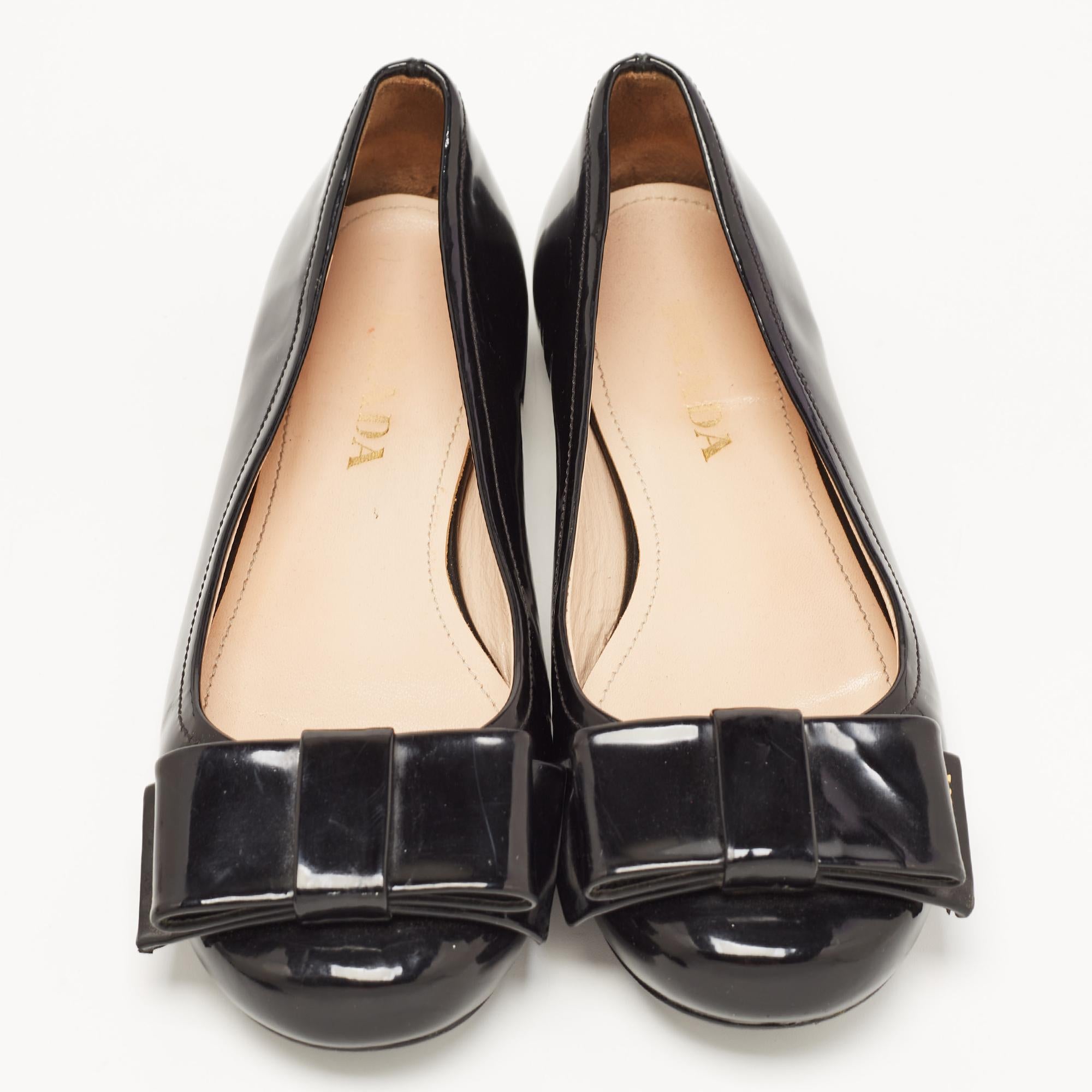 These Prada ballet flats are perfect for channeling an air of elegance! These black flats have been crafted from patent leather and styled with round toes and bows. They are complete with comfortable insoles and tough soles.


