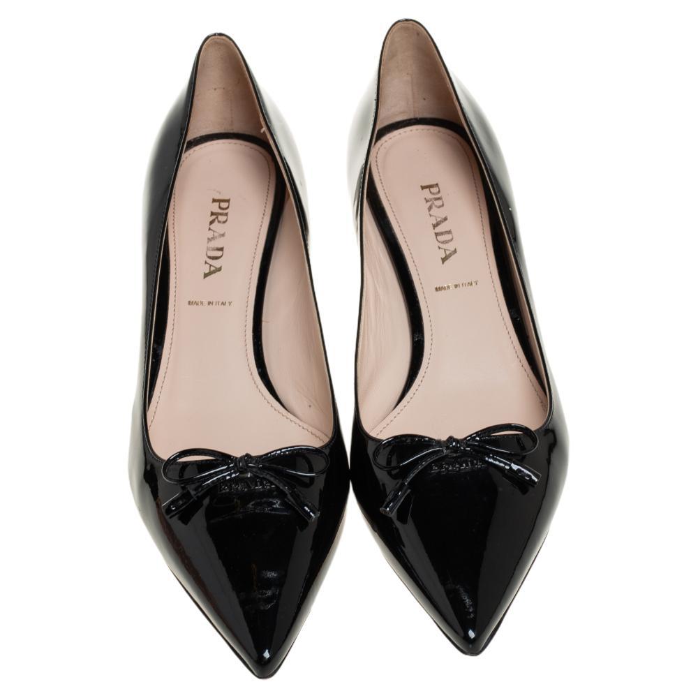 These pumps by Prada are simple and timeless. Crafted using patent leather, the pumps carry a black exterior with bows over the pointed toes. They are complete with kitten heels. Slip into them and you are sure to create a stunning look.

Includes: