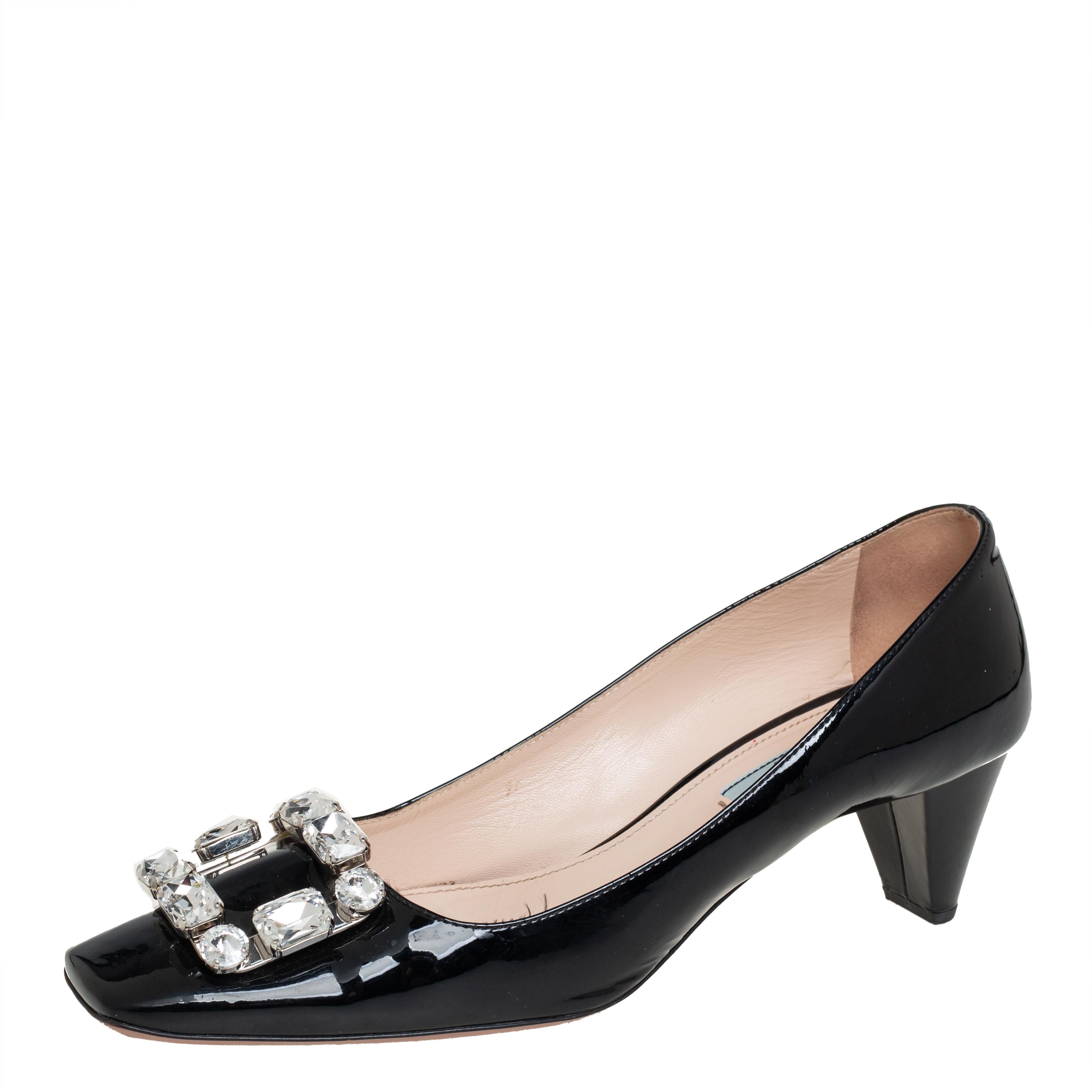Add this exquisite pair of Prada pumps to lend an added element of comfort. Feel beautiful and be comfortable while flaunting these patent leather pumps, enhanced with crystal embellished buckle detail on the vamps. Upgrade your everyday look by