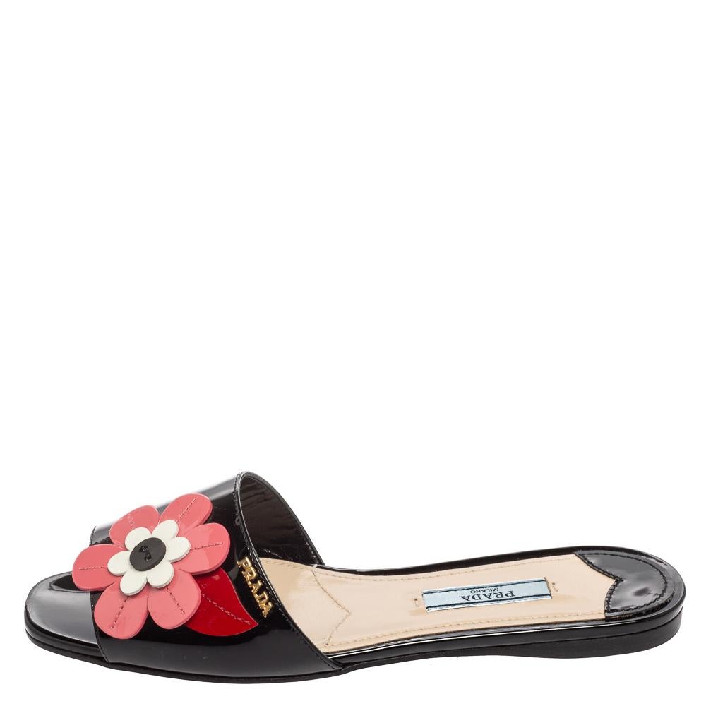 For days of ease and style, Prada created these flat slides. They have uppers made from patent leather with flower appliques in black rose shade and insoles lined with leather for comfort. The slides will come in handy with many of your
