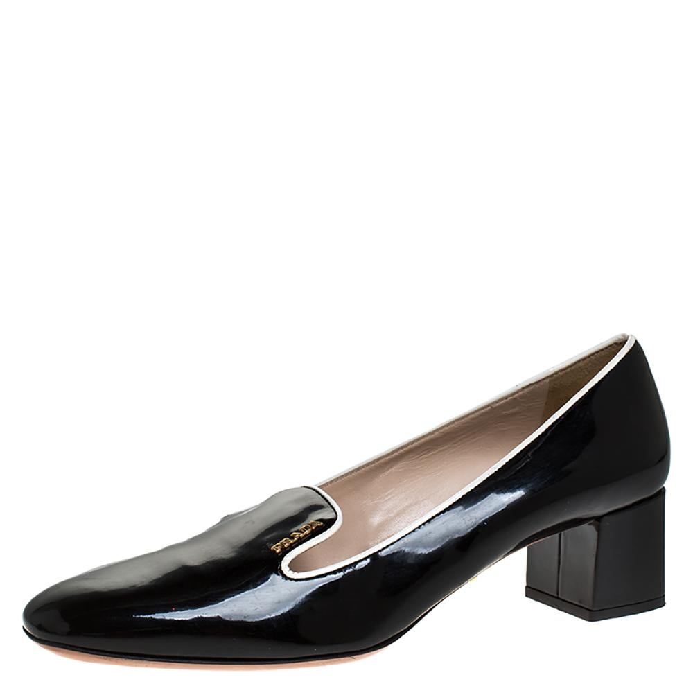 These stylish loafer pumps come from the iconic house of Prada. Crafted in Italy, they are made from patent leather and have a glossy black exterior. They are styled with square toes, contrast trims, gold-tone logo detailing on the front, 4.5 cm
