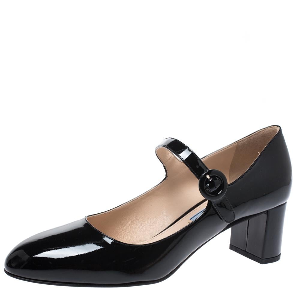 These stylish Mary-Jane pumps come from the iconic house of Prada. Crafted in Italy, they are made from glossy patent leather. They come in a classic shade of black and will complement a host of outfits. They are styled with round toes, buckled