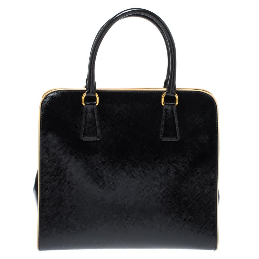 This stunning bag is high on appeal and style. Dazzling in a classy black hue, the bag is crafted from patent leather and features two rolled handles and a shoulder strap. The snap button leads way to a nylon-lined interior with enough space for