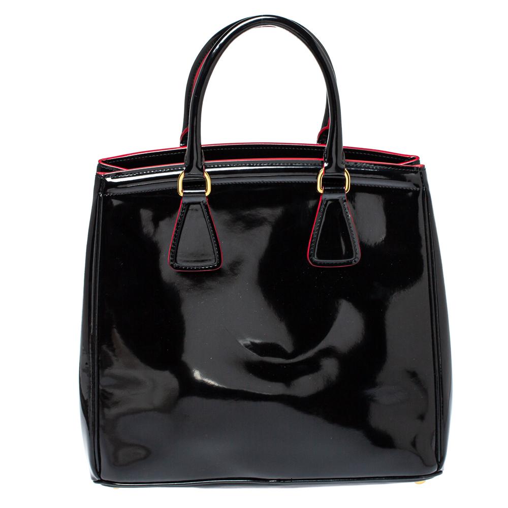 Meticulously created, this Parabole tote by Prada is a style statement in itself. Designed from glossy patent leather into a sturdy shape, it exudes style and class in equal measures. This delightful black-hued piece is held by two top handles and