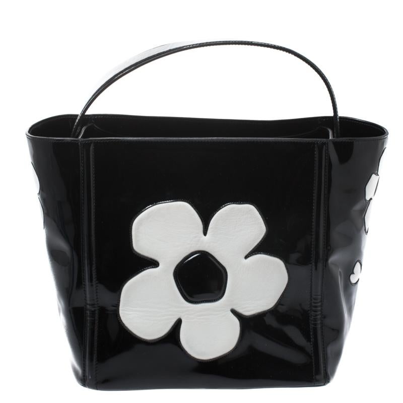 Wenn Sie diese Kreation von Prada tragen, können Sie sich auf bewundernde Blicke gefasst machen, denn diese Tasche ist stilvoll und praktisch. Die Tasche wurde aus Lackleder in einem schönen Schwarzton gefertigt und ist außen mit einem