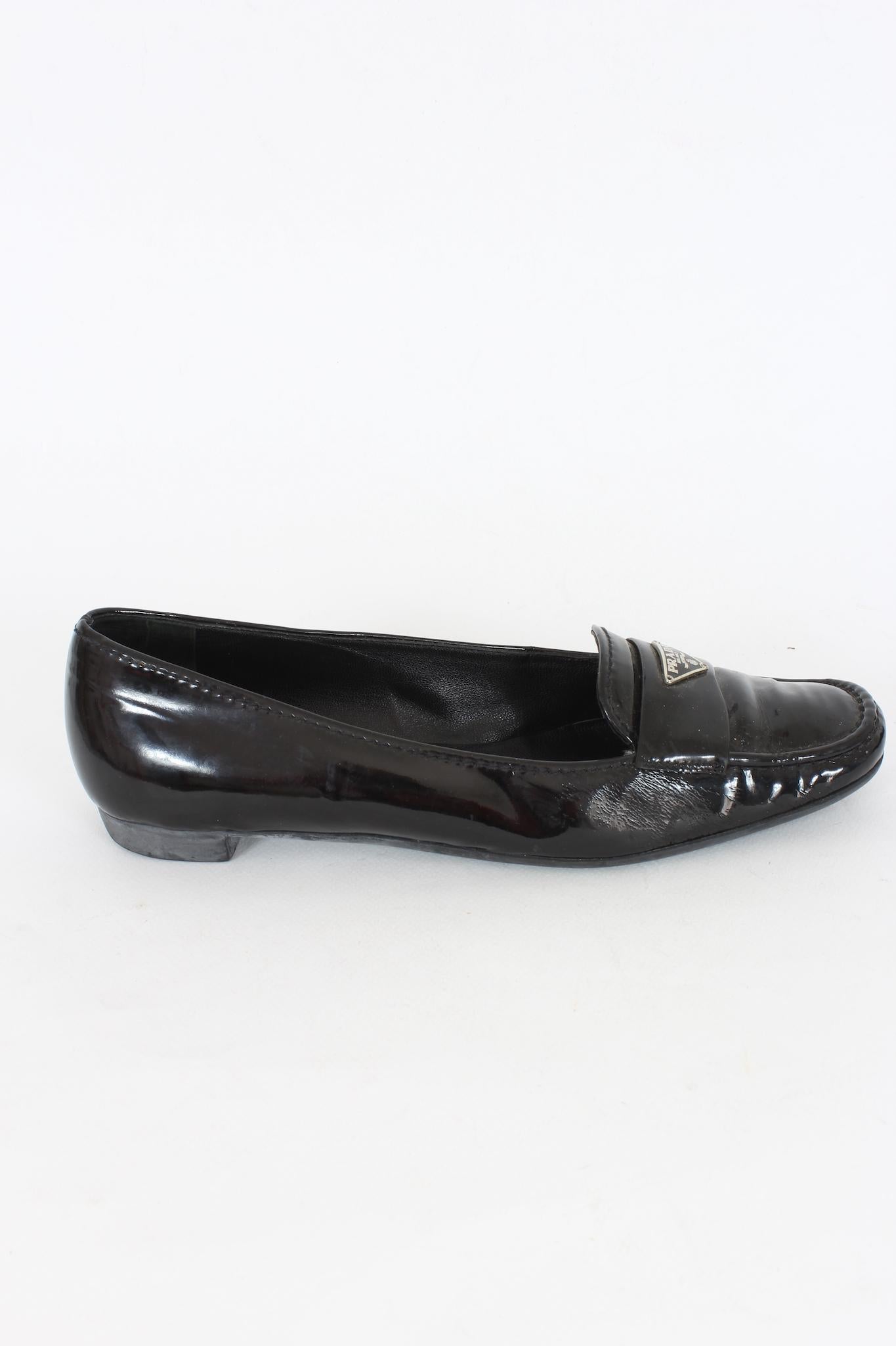 Prada vintage 90s shoes. Moccasins model in black patent leather with raised silver-colored logo. Rubber sole. Made in Italy.

Size: 39 IT 9 US 6 UK

Length: 26 cm

