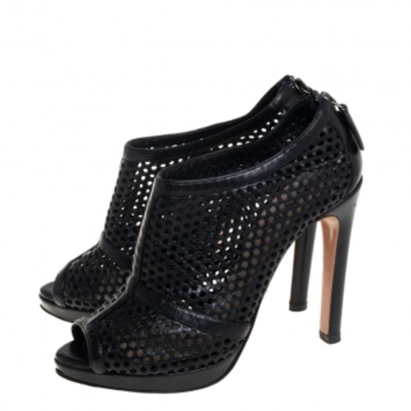 Step out in style and grab attention with these lovely open-toe booties from Prada. The splendid black booties are crafted from leather and feature a perforated design. They flaunt trendy back zippers, leather-lined insoles, and an 11 cm heel. Wear