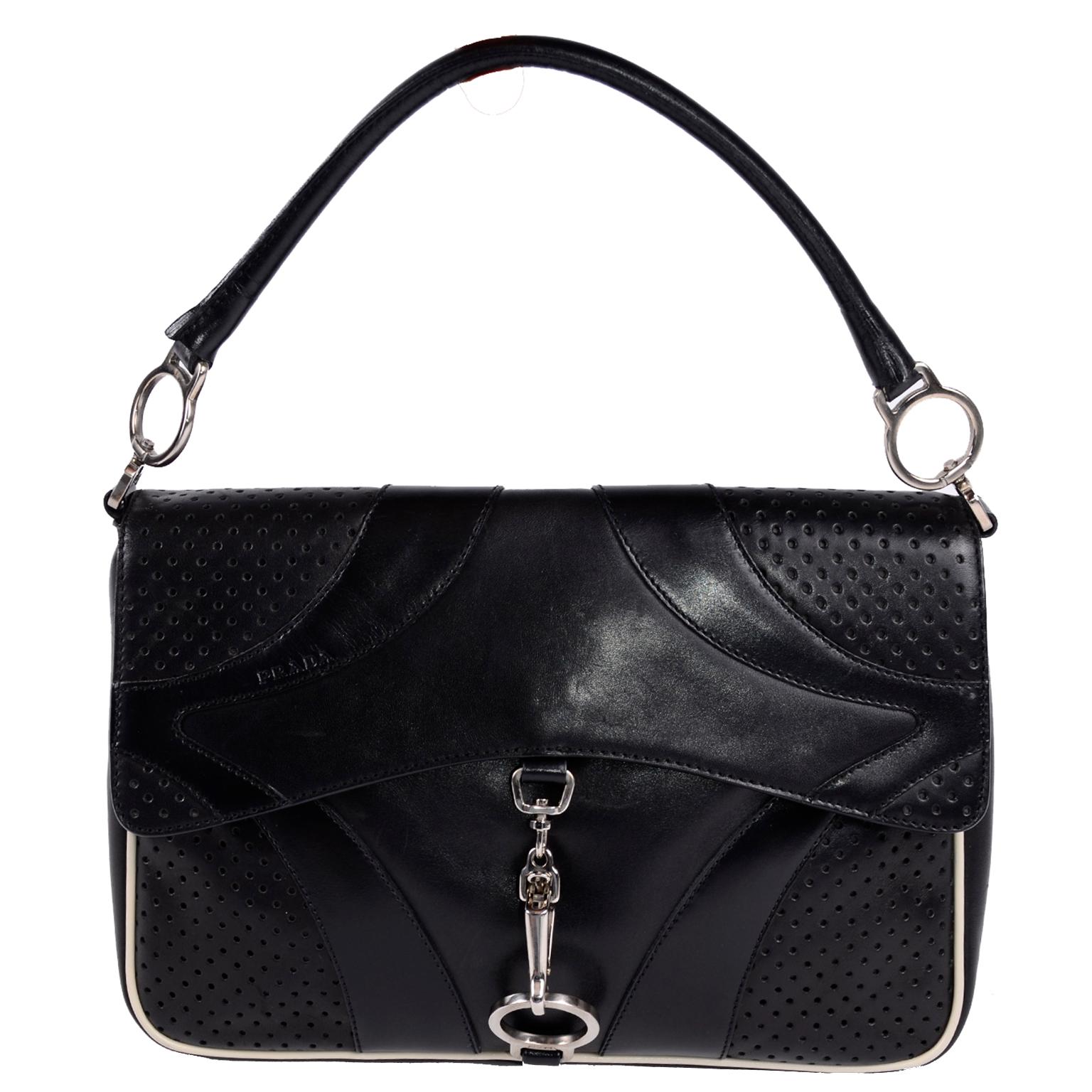 This is a great on trend authentic Prada Black Leather handbag with silver hardware, perforations and top-stitch quilting.  This vintage bag has an Inside zip pocket and white trim leather 