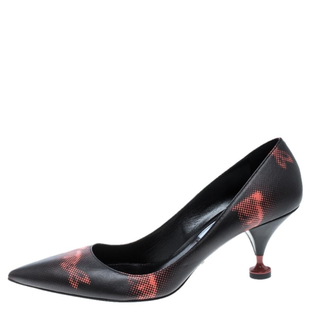 Step out elegantly in these pumps from Prada. They feature a black leather exterior accented with highlighting red print all over, pointed toe and kitten heels. The insides are also leather-lined and they carry the brand's iconic label. Wear this