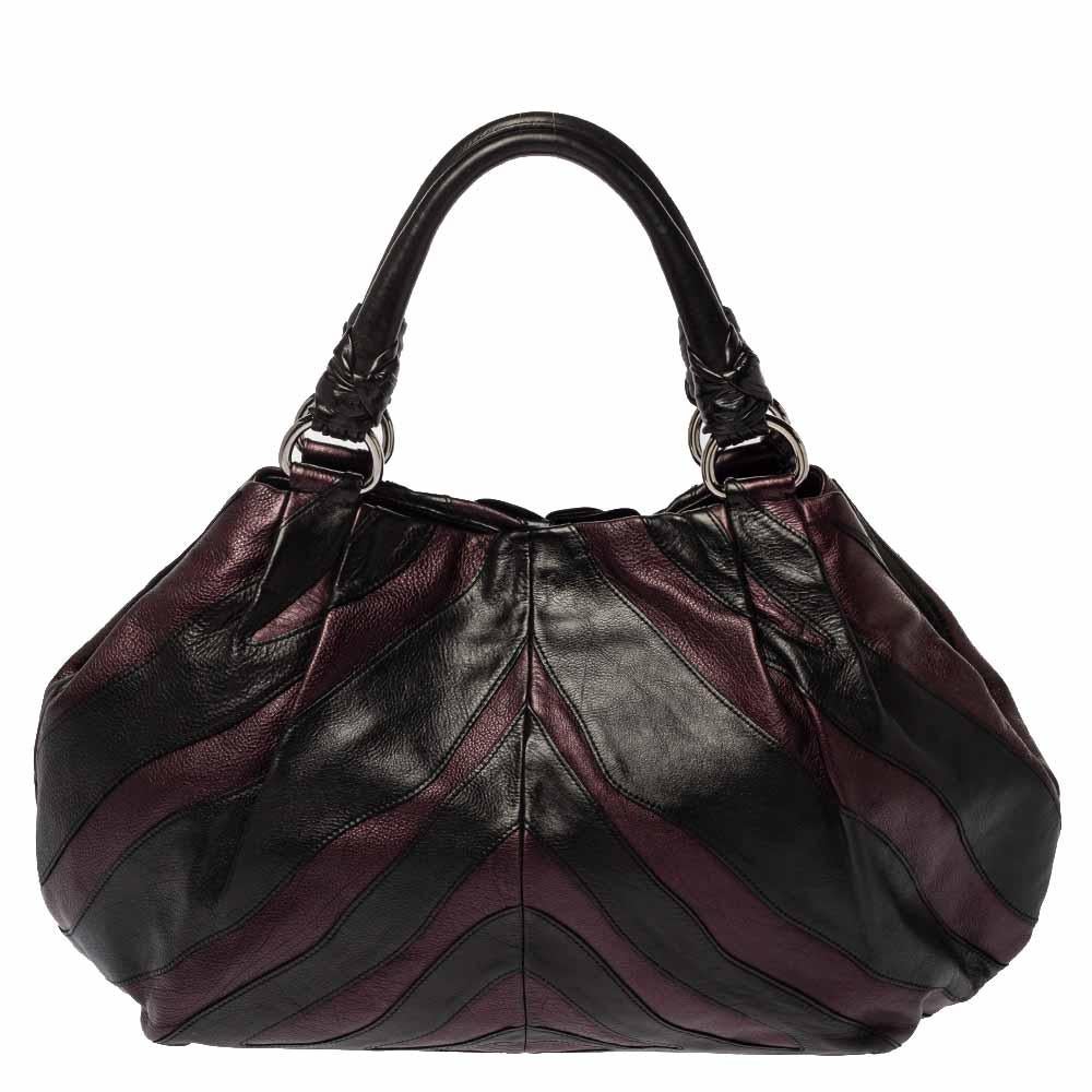 Prada never fails to impress and this Mordore hobo aptly justifies that. This black-purple hobo is crafted from leather and features a chic silhouette. It flaunts a ruffle and stripe detailing all over and comes equipped with dual top handles with