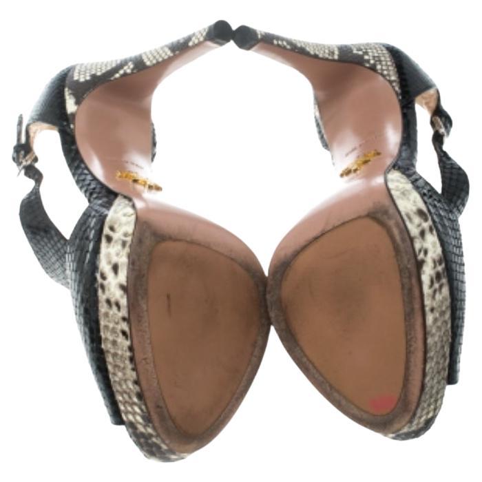 Enfilez cette paire de sandales à plateforme signée Prada et enthousiasmez votre public où que vous alliez. Elles ont été magnifiquement confectionnées en cuir de python et conçues avec des découpes, des peep toes et des boucles. Des talons de 11,5