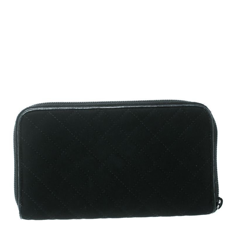 Prada's wallet is bang on trend and practical addition to your wardrobe. Black quilted fabric exterior is adorned with a metal Prada plaque. Silver-tone zip-around closure secures the bag. The wallet has ample space for your cardholders, cash, and