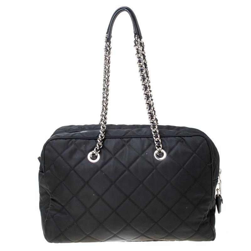 Impeccably crafted, this Prada bag is perfect for the stylish woman in you. The black nylon bag comes with interwoven chain handles, quilted exterior and a zip-top closure. The interior is spacious and features a zipped pocket that will safely hold