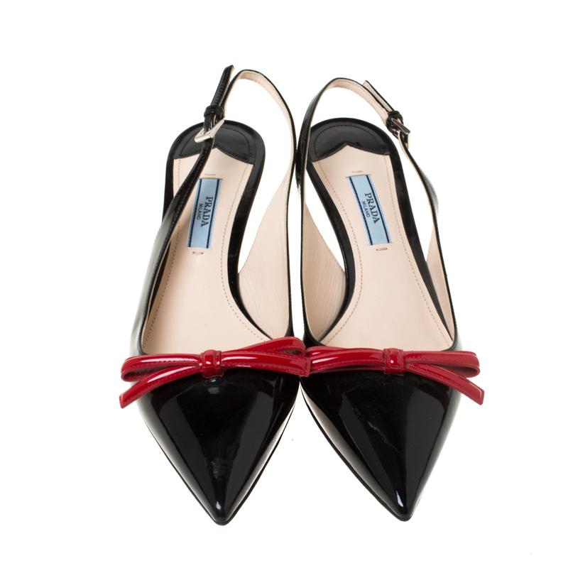 These black sandals are the epitome of elegance and poise. From the fashion house of Prada, they are crafted from patent leather and feature pointed toes, bow details on the vamps and slingback straps. The insoles are leather lined and carry the
