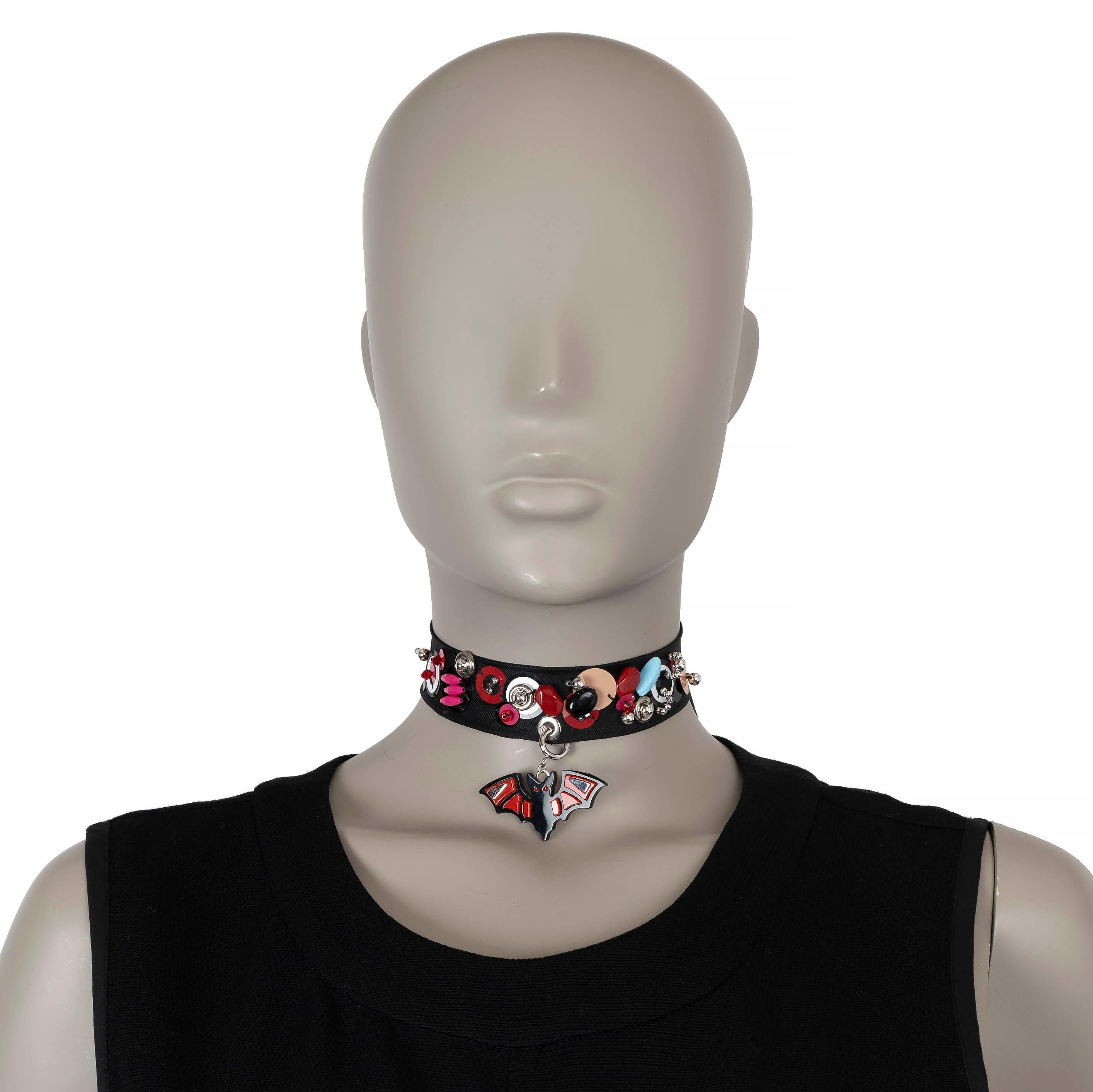 Questo 100% autentico Prada Runway Punk Bat Pendant Bead-Embellished Choker è un pezzo raro e iconico della collezione 2017 di Prada. Realizzato con un audace girocollo in stile cravatta nera, presenta un ciondolo a forma di pipistrello ornato da