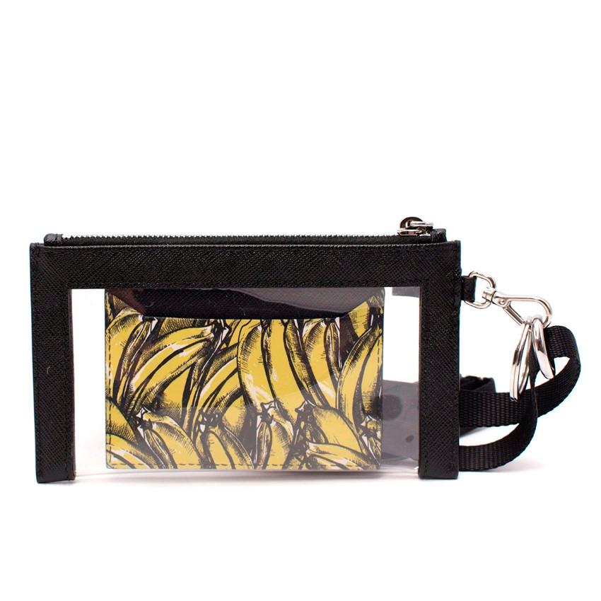 Prada Black Saffiano & Banana Print Lanyard Card Holder
 

 - Black saffiano leather card holder with a banana print and logo to the corner
 - Comes with zip-up transparent pouch finished with triangle applique and removable strap
 

 Materials:
