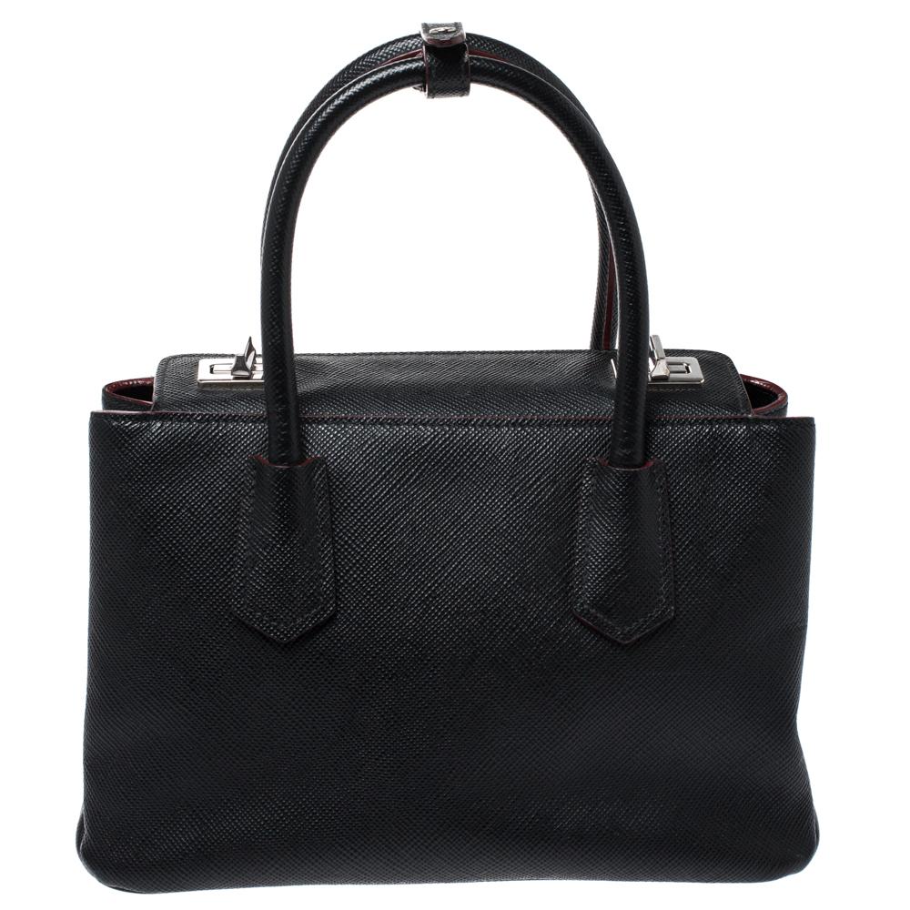 Prada introduces this beautiful piece for the smart woman. Crafted from Saffiano Cuir leather, the bag features dual handles and a shoulder strap. Dual turn-locks on the top lead to a spacious interior that has a zipped compartment. This bag will