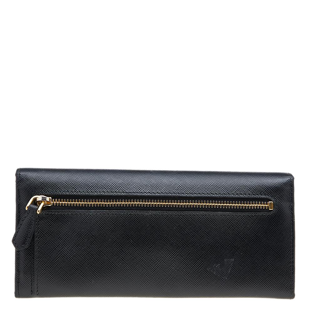 This designer continental wallet by Prada has a beautiful look. Crafted from quality leather, it comes in a black shade. It has a front flap with a bow detail that adds charm and its lined interior has enough space for all your