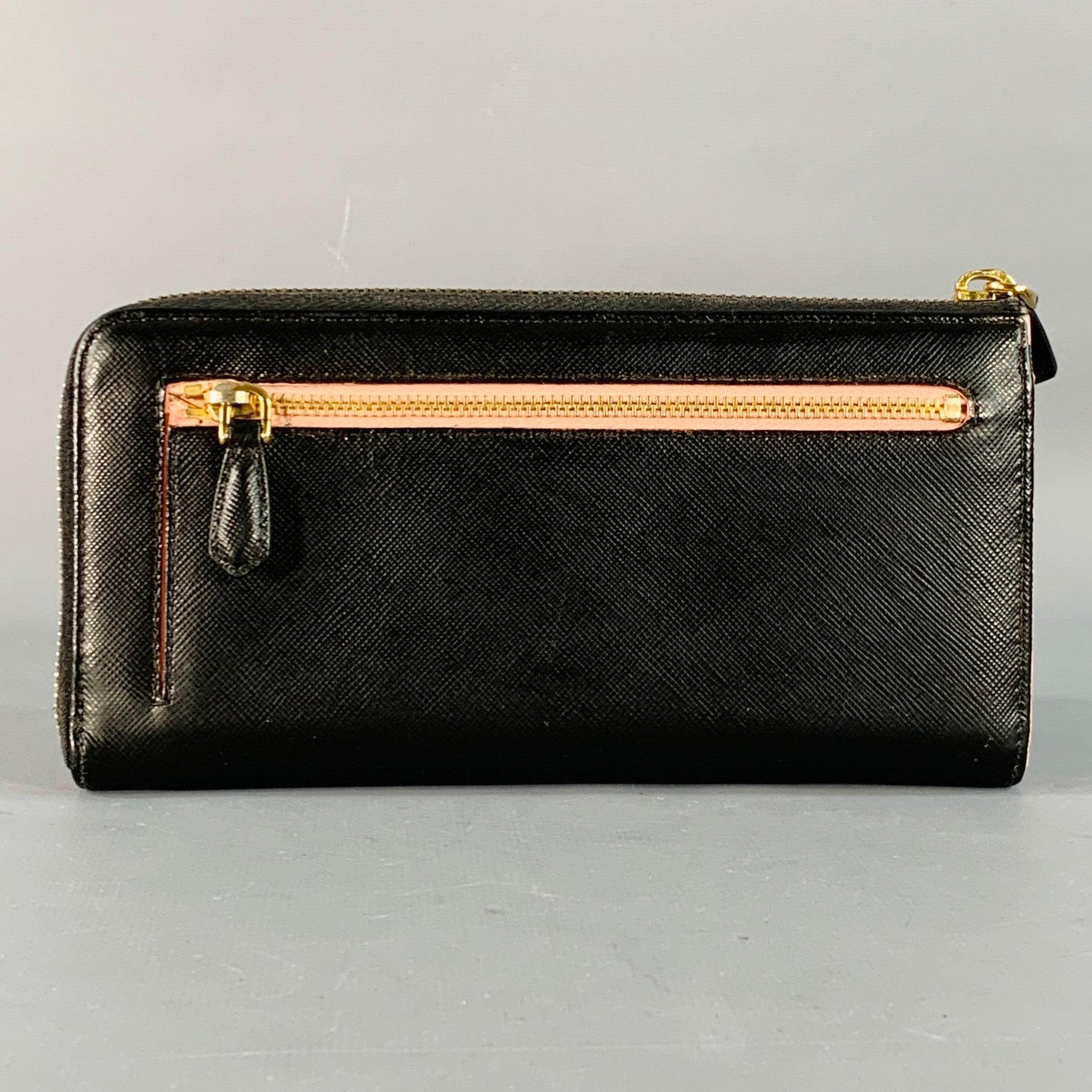Portefeuille chéquier PRADA
en cuir saffiano noir, avec un nœud noir et un logo en métal doré, plusieurs fentes pour cartes, un porte-monnaie central zippé et une fermeture à glissière. Livré avec sa boîte. Très bon état. 7.5 x 3.75 pouces 
  
  
