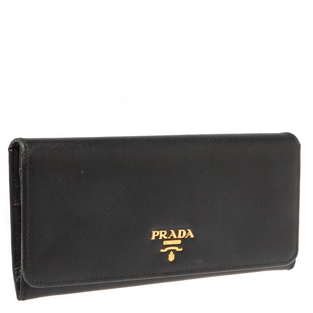Durable and long-lasting, this black continental wallet from Prada is crafted from Saffiano leather. Showcasing an exclusive design, it makes for a stylish as well as a convenient accessory. It flaunts a gold-tone brand logo detailing on the front