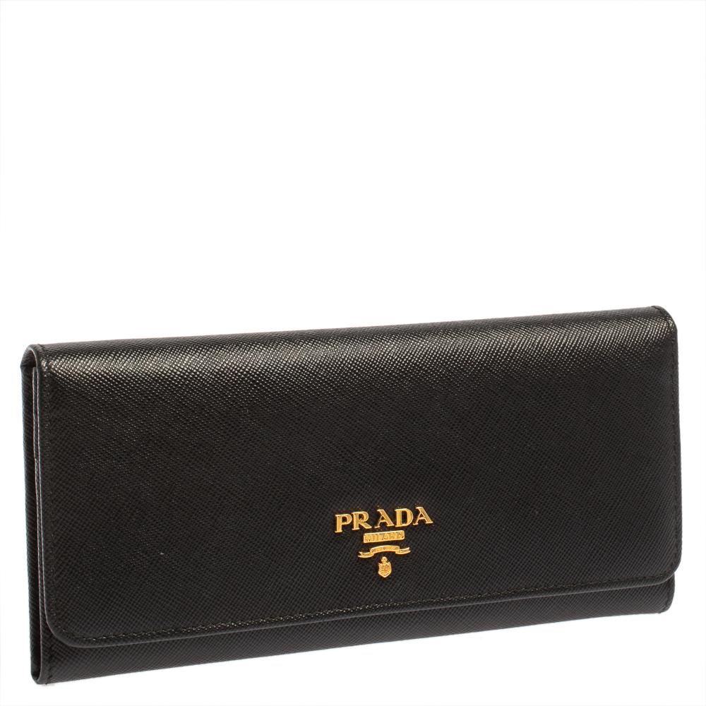 Basic essentials can be carried effortlessly in this black Prada continental wallet. Crafted from Saffiano leather, the flap style wallet features the brand detail at the front and inside. It has multiple card slots, open compartments, and a zip