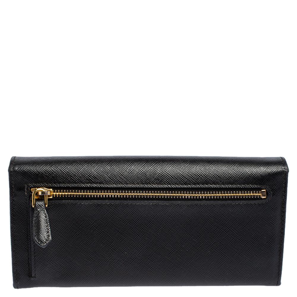 Take this spacious and functional flap wallet by Prada everywhere you go. Made from black Saffiano leather, this flap wallet is accented with a gold-tone logo. The easy to organize interior is lined with leather & fabric and features compartments,