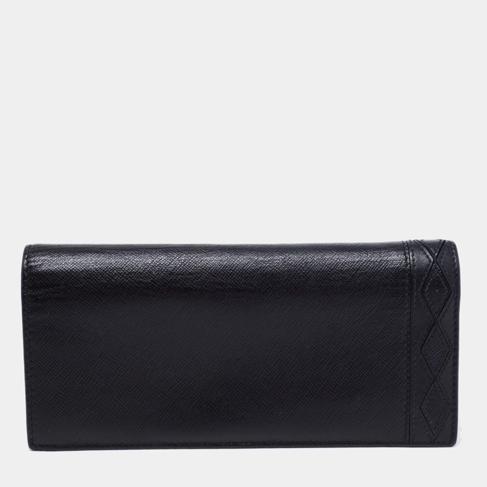 This Prada wallet is an immaculate balance of sophistication and rational utility. It has been designed using Saffiano leather and is elevated by a sleek finish. The black-hued, long bifold wallet is equipped with ample space for your monetary