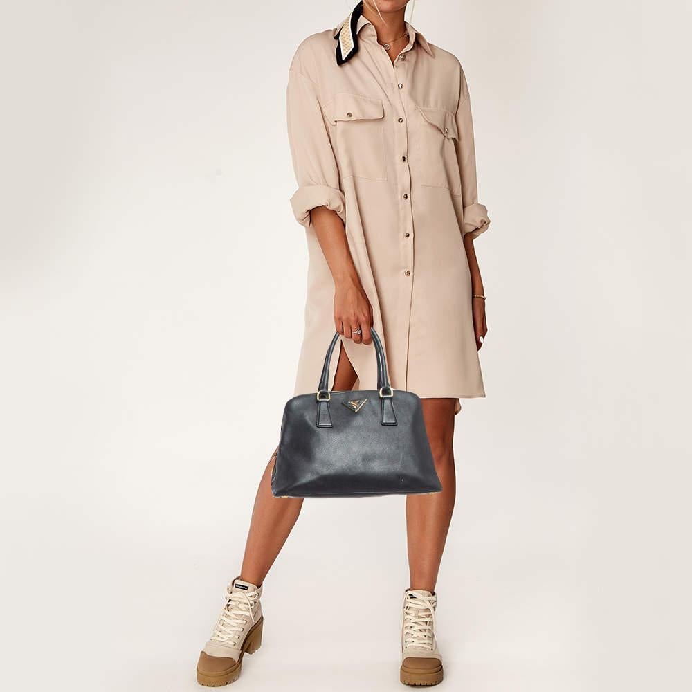 This Prada handbag beautifully shows quality craftsmanship. The interior of this gorgeous bag is lined with nylon and secured by a top zipper. The brand logo shines on the front.