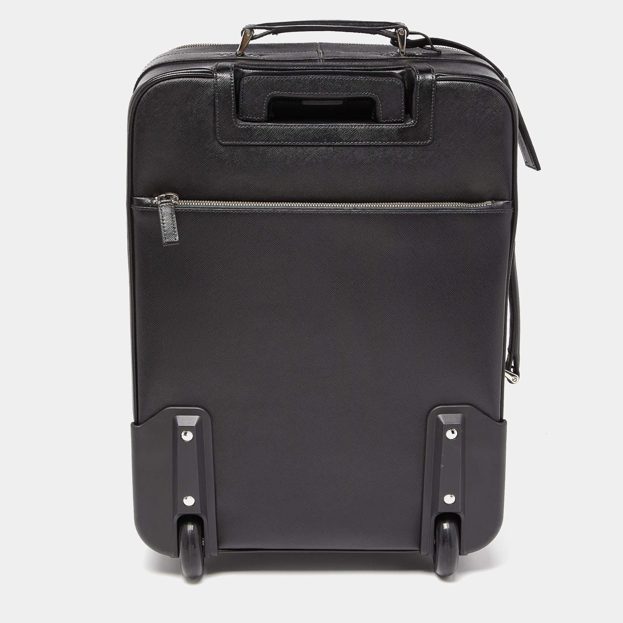  Say hello to your new traveling partner from Prada. The exterior has been crafted from Saffiano leather while the spacious interior is lined with nylon. Equipped with a zip pocket at the front, a flat handle, two wheels, and a telescopic cane, this