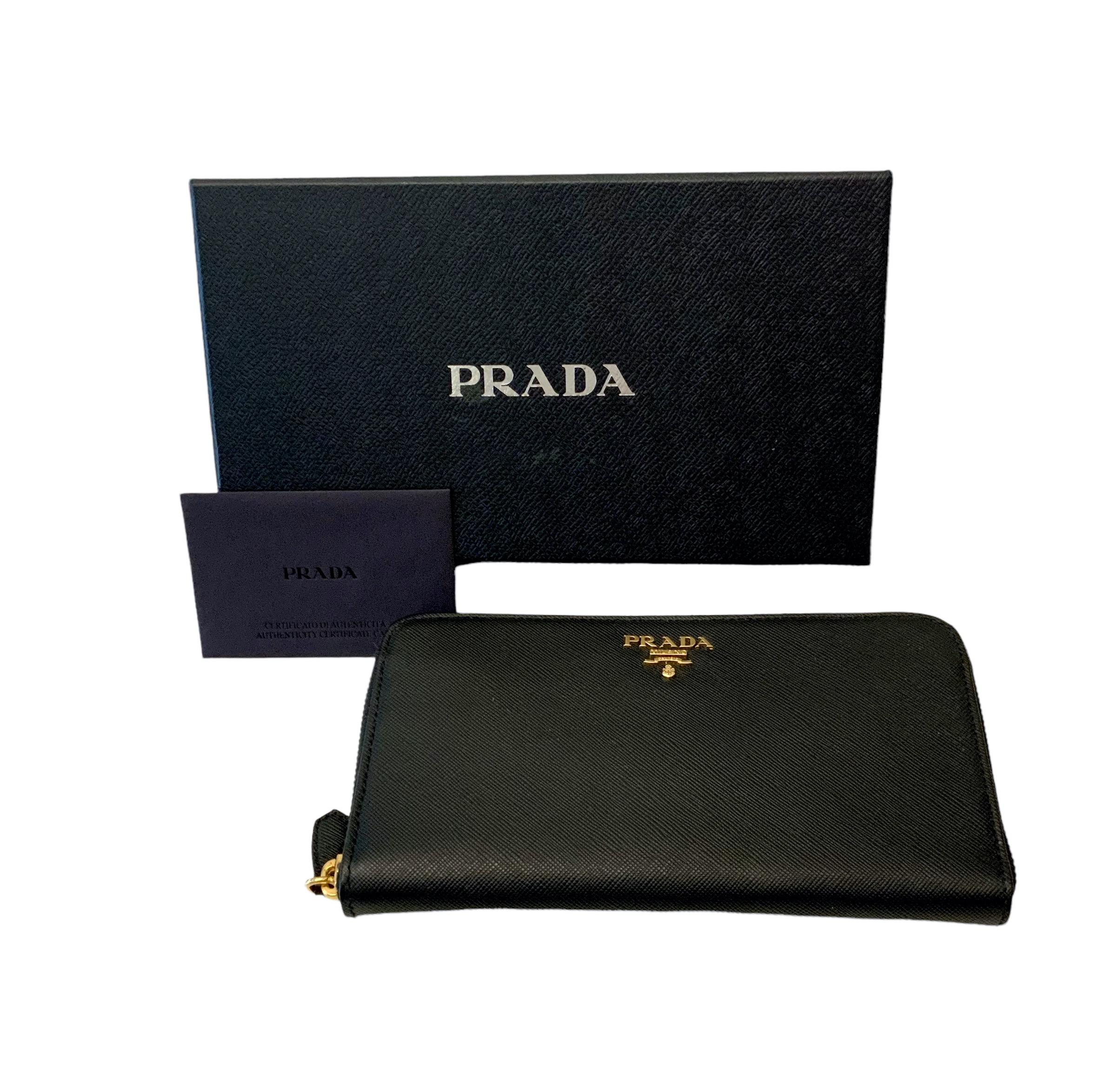 This pre-owned but new Saffiano leather wallet is decorated with gold-tone metal Prada lettering. 
It features an all-round zipper revealing 8x card slots, 2x flat pockets, 2x bill compartments and a zippered compartment for coins.

Material: