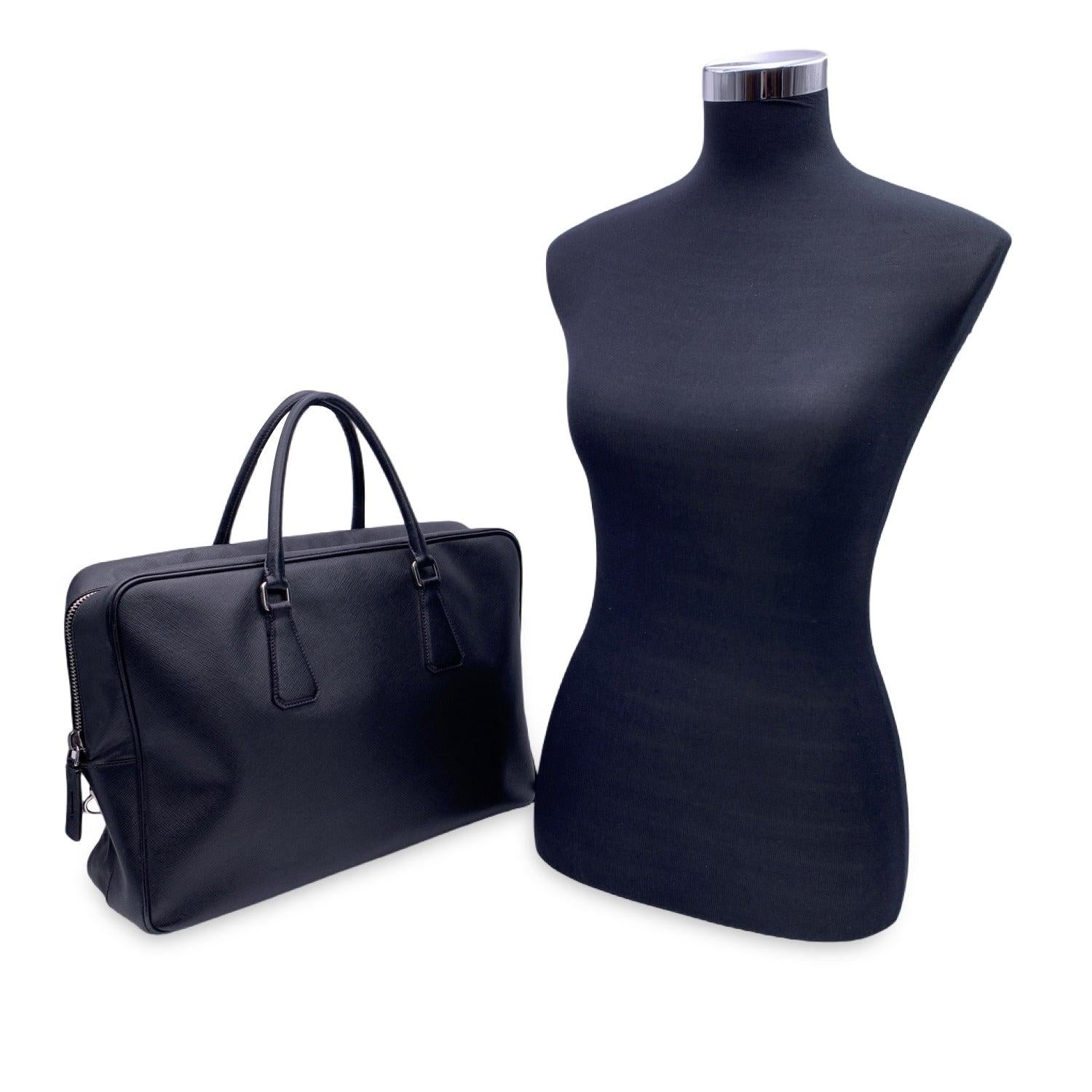 Prada black Saffiano leather briefcase work bag. Upper zipper closure. Double handles. Black fabric lining. 2 side zip pockets, 1 side open pockets and pen holder inside. 'Prada Milano' tag inside. Condition B - VERY GOOD Gently used. Light wear of