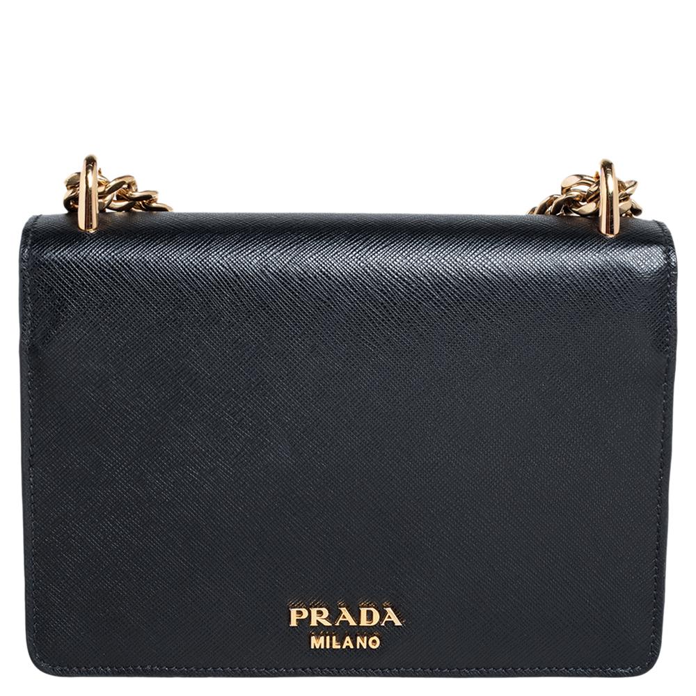 This crossbody bag from Prada is crafted from black Saffiano Lux leather & soft calf leather and is held by a long shoulder strap. The bag features a gold-tone brand logo detailing on the front flap and a nylon-lined interior that can house your